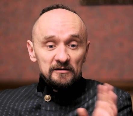 Dynamiczna scena teatralna w stylu Jana Klaty, z nowoczesną scenografią i intensywnym oświetleniem.